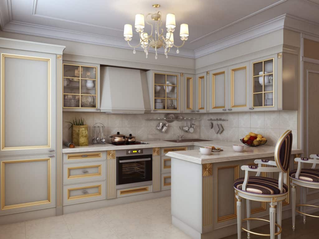A kitchen with white cabinets and gold finishes